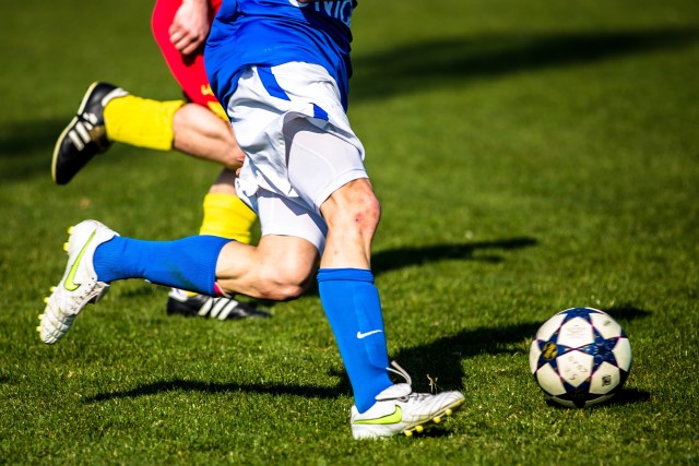 Zwei Spieler verfolgen einen Fußball